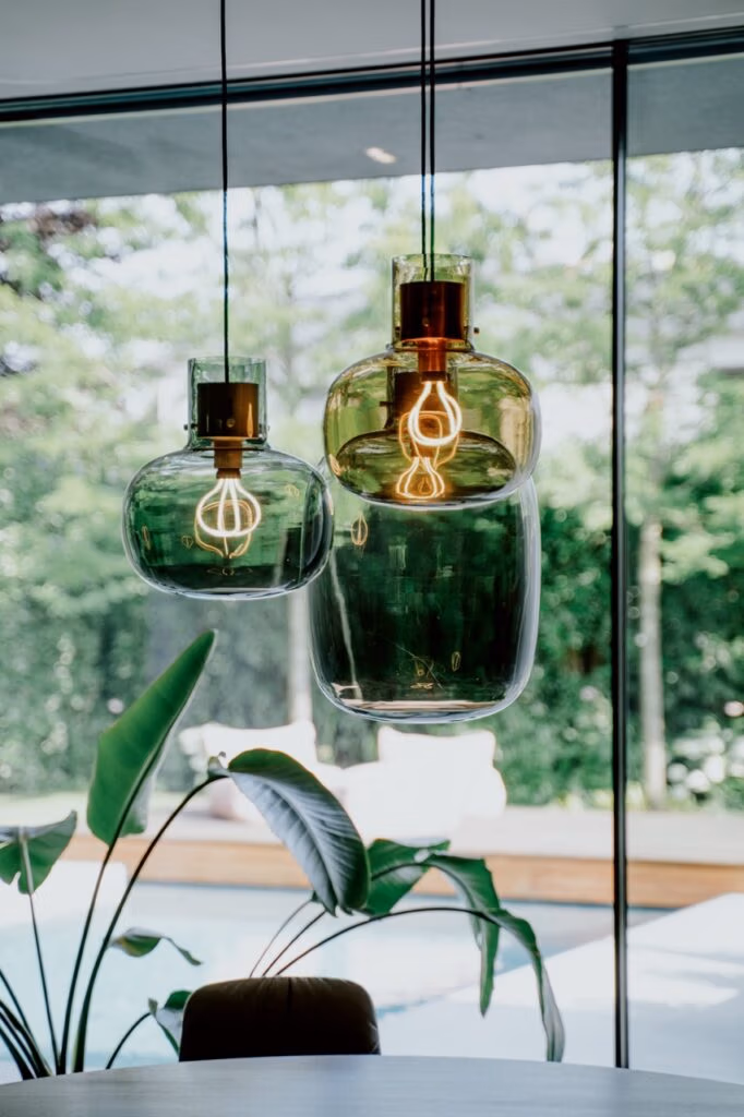 Private Räume mit Pendelleuchten, Fensterblick und atmosphärischem Lichtkonzept als Detail im Interior Design.