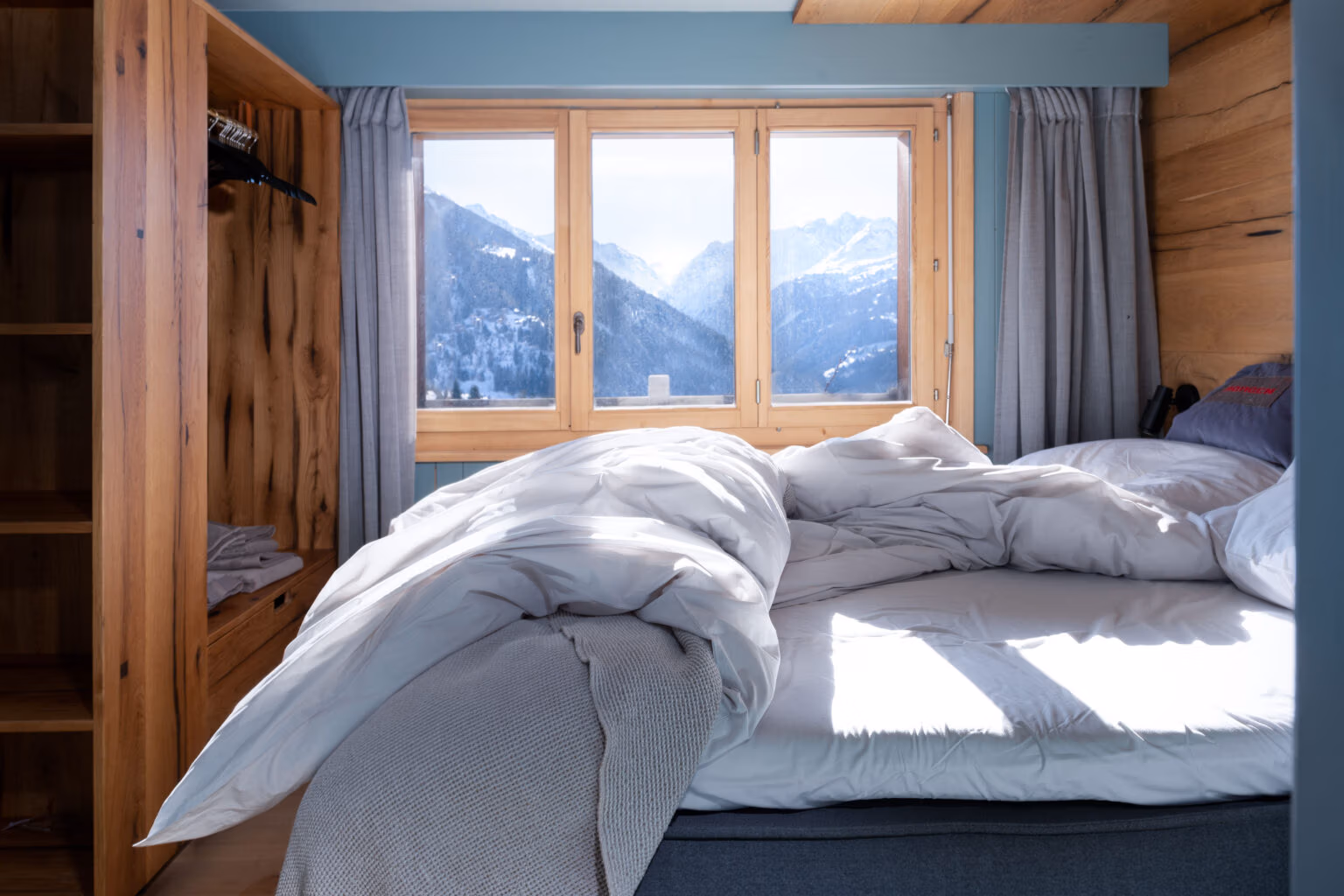 Schlafzimmer als privater Rückzugsort mit Bergblick, Holzoberflächen und Interior Design für eine Ferienimmobilie.